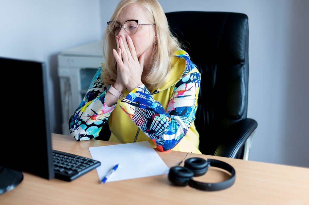 Middle aged tired, stressed and frustrated business woman desperate working at office with computer